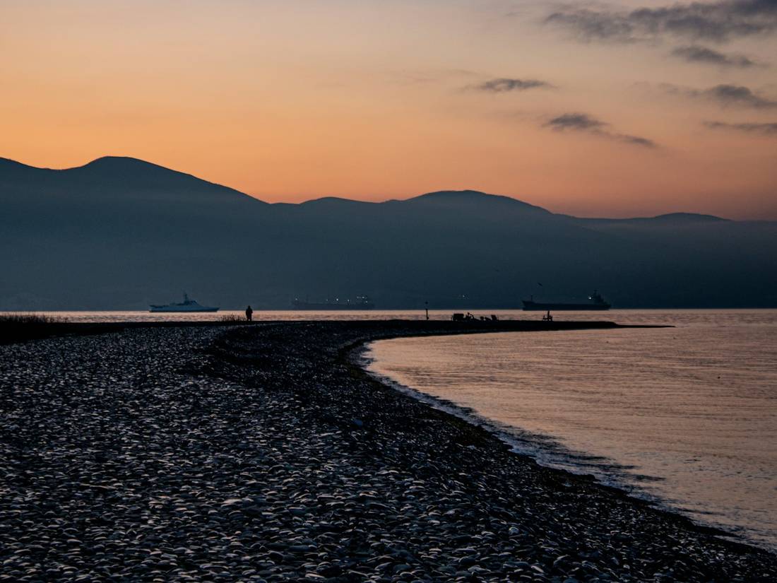 Sunset over mountains and a pebble beach