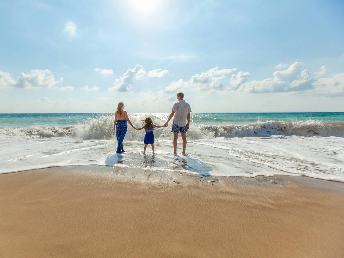 A family holding hands on the seashore