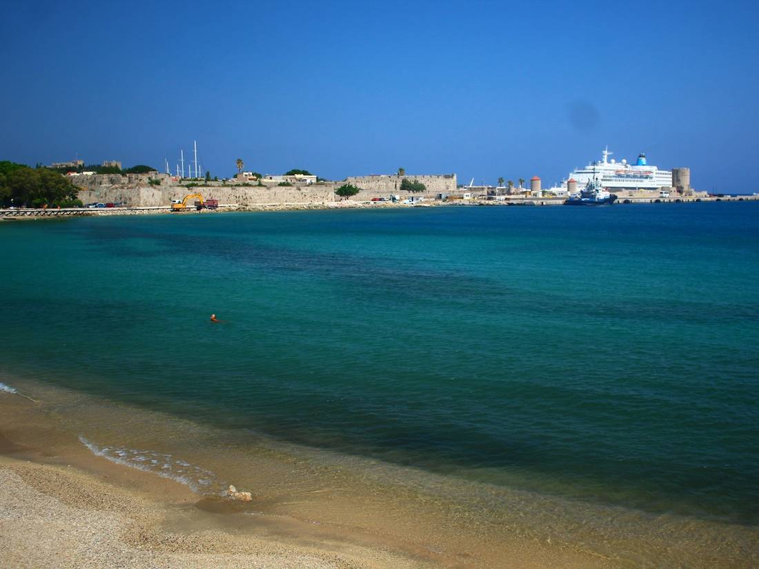 Cruise ship anchored off a walled Mediterranean town