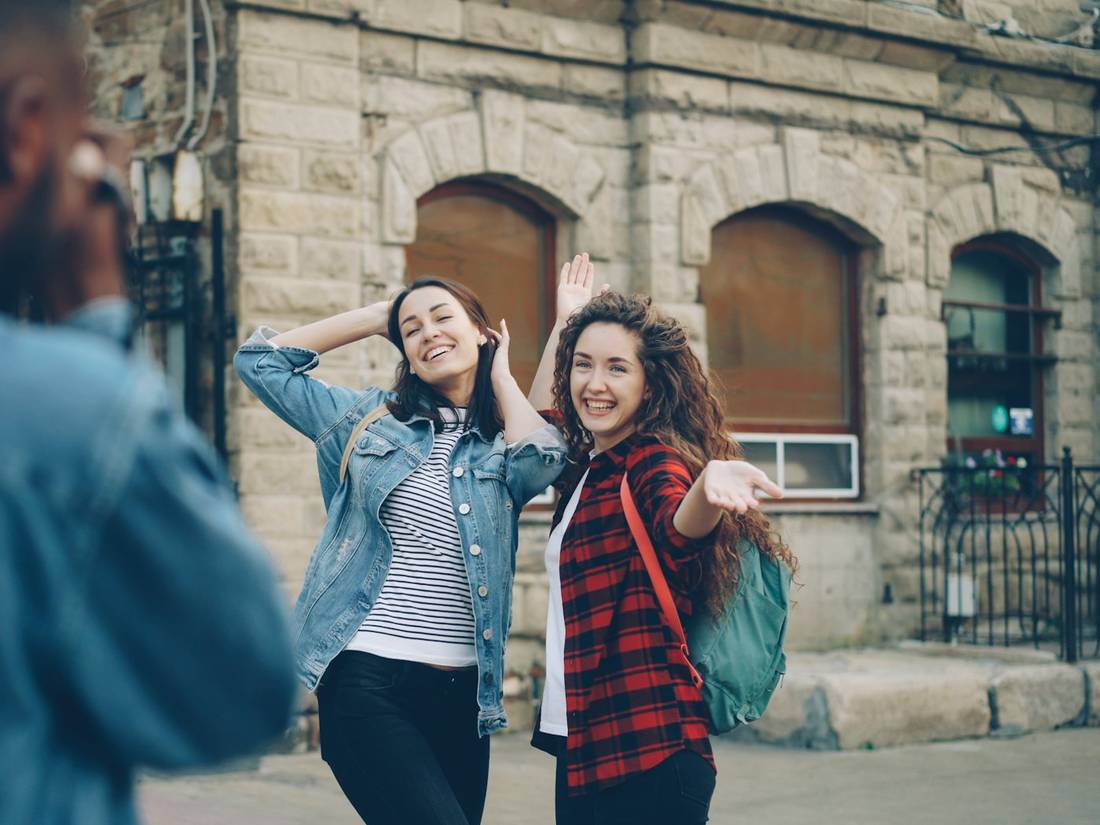 Friends posing for a photo on a city street