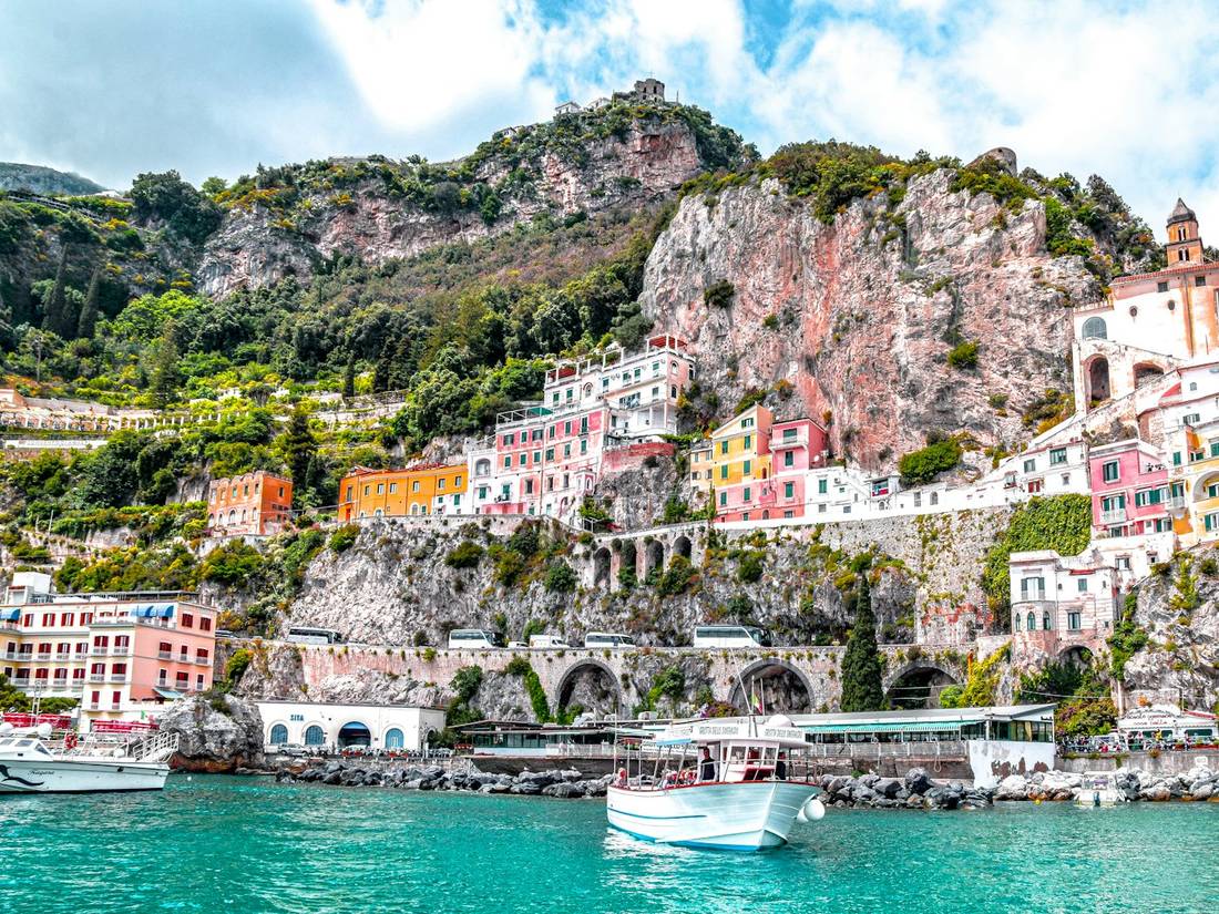Colorful buildings on a cliffside above turquoise water