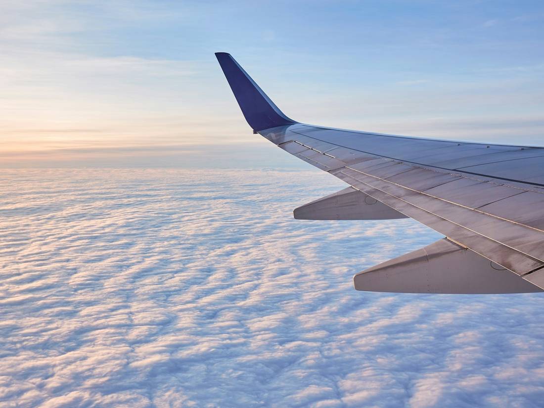An airplane wing above the clouds