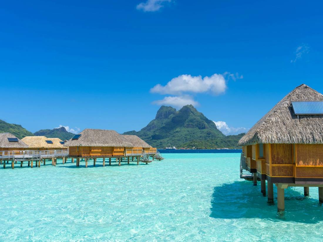 Overwater bungalows on clear blue water